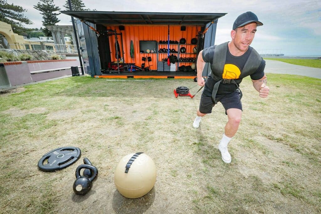People taking part in a Meke Foundation community fitness session beside a container gym in Hawke’s Bay